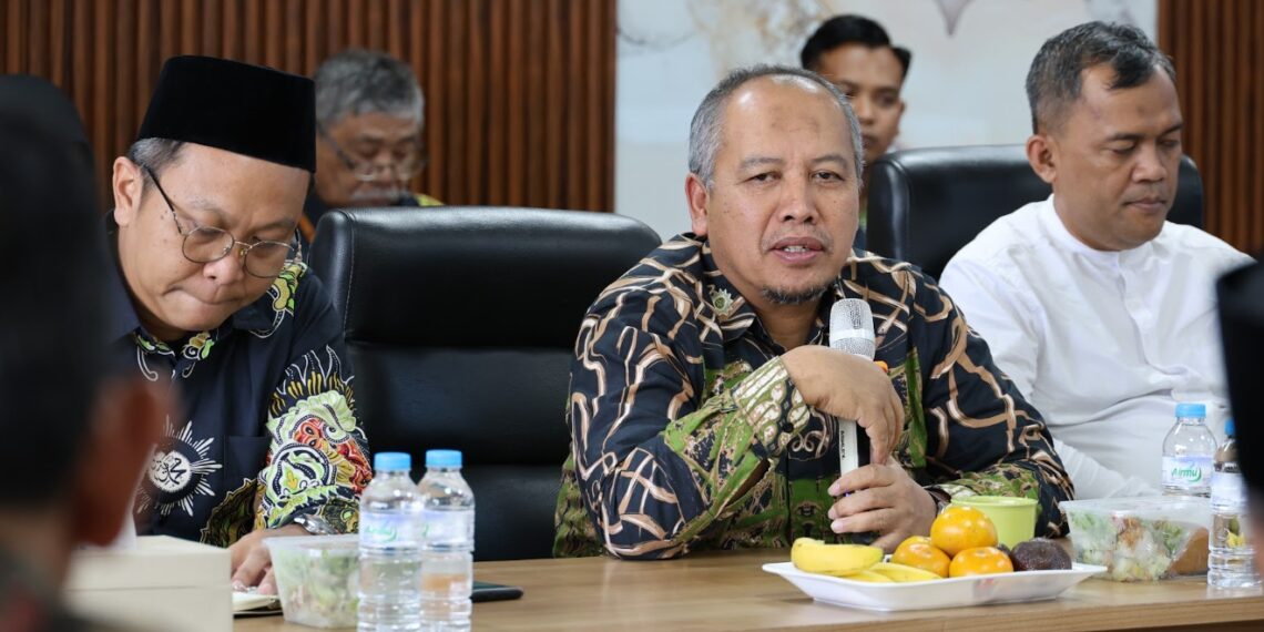 Ketua BOMK PWM Jateng Prof. Dr. apt. Muhammad Da’i, M.Si. berbicara menggunakan mikrofon saat memimpin Rapat Pleno membahas reformasi manajemen Muhammadiyah.